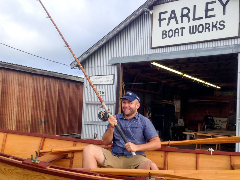 Chet Garner in a boat in front of Farley Boat Works
