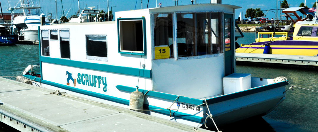 White boat in wter with Scruffy painted on the side